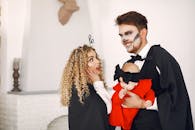 一家三口穿着创意服装，在室内涂着脸享受万圣节