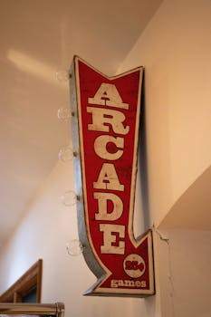 A red vintage arcade sign with retro typography, signaling arcade games for 25 cents.