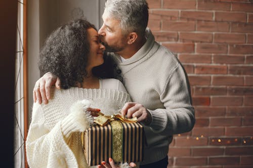 Free Loving Husband Giving a Christmas Present to His Wife Stock Photo