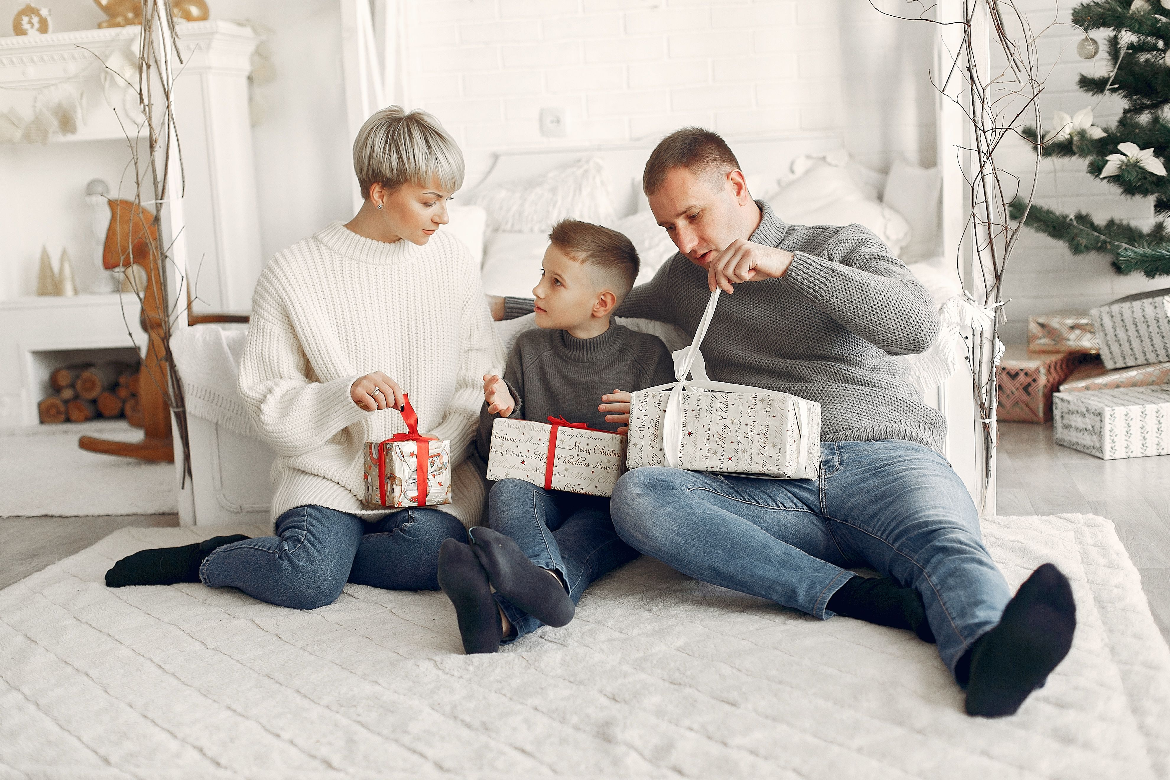 Family unwrapping Christmas presents by the fireplace — sharing the joy of a gift basket together