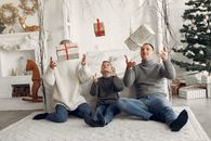 Family Sitting on Floor and Enjoying Christmas Gifts