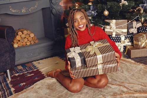 Smiling Woman with Presents near Fireplace