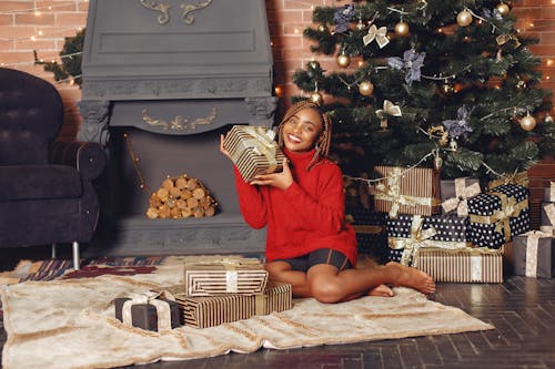 Smiling Woman with Presents near Fireplace