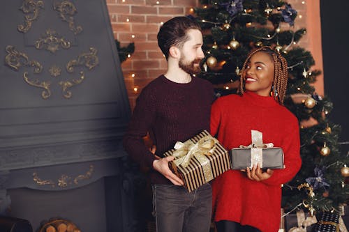 Couple with Gifts near Christmas Tree