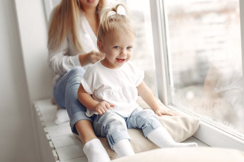 Mother and Daughter Sitting on a Windowsill