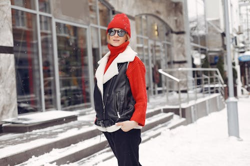 A Woman Standing in the Sidewalk Wearing Winter Clothing