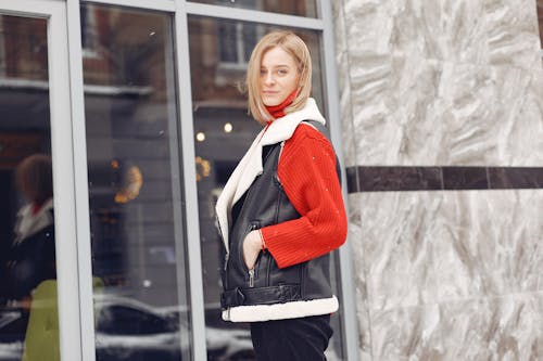 Woman Wearing a Black Vest Standing Beside Glass Window
