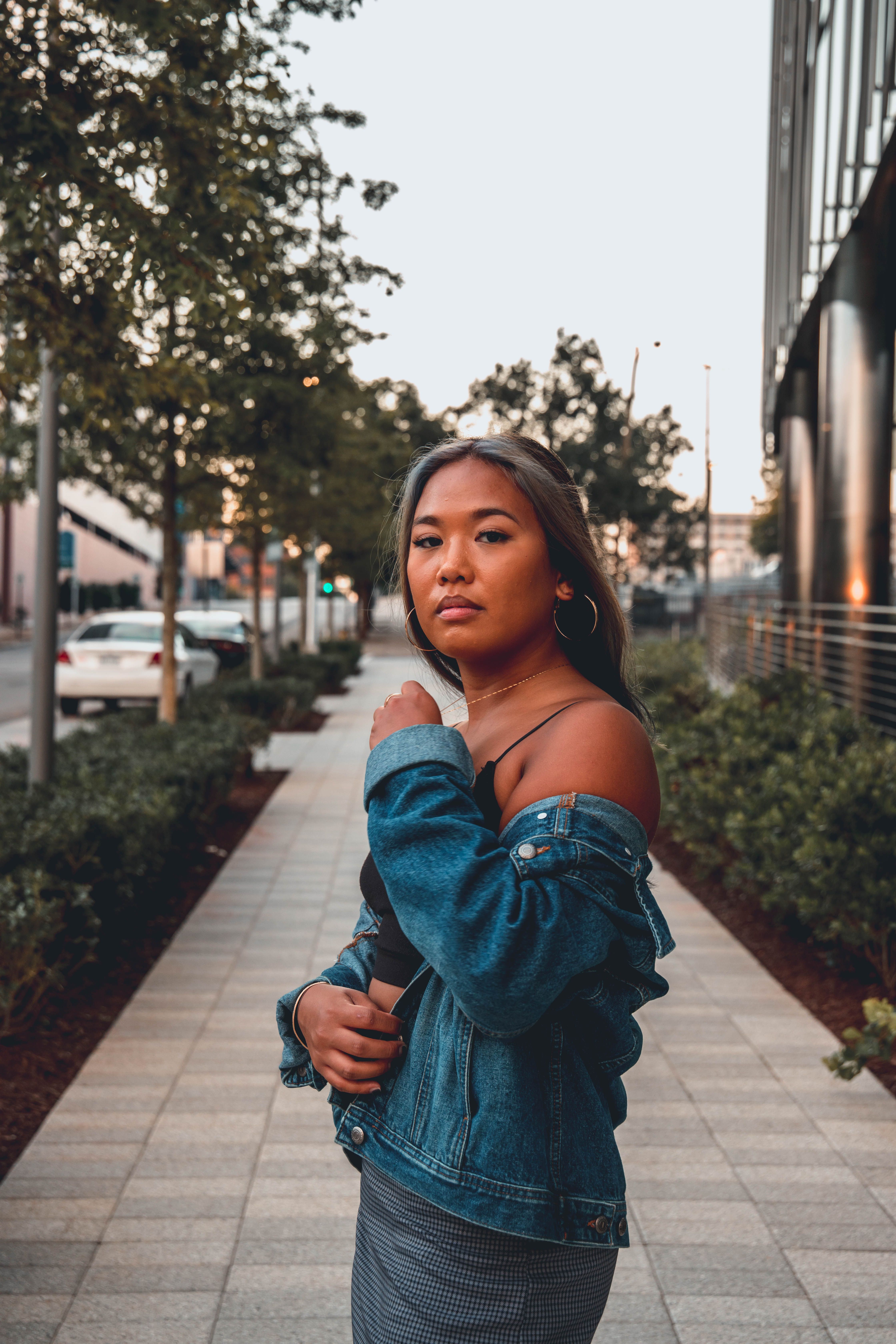 Woman in Blue Denim Jacket Standing on Sidewalk · Free Stock Photo