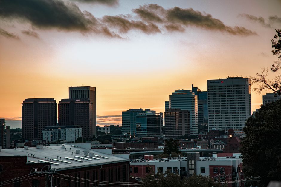A vibrant city skyline with high rises under a dramatic sunset sky.