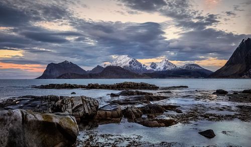 Free Spectacular view of rough rocky formations near ocean under bright cloudy sky at sundown Stock Photo