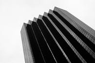 低角度拍摄的现代玻璃摩天大楼，设计时尚，映衬着多云的天空