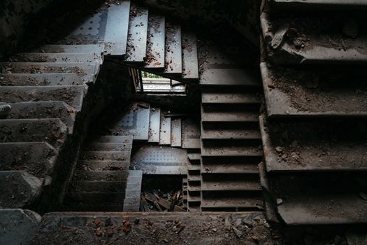 Explore this dramatic view of an abandoned spiral staircase in a dilapidated building.