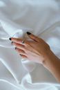 Person Wearing Silver Ring on White Textile