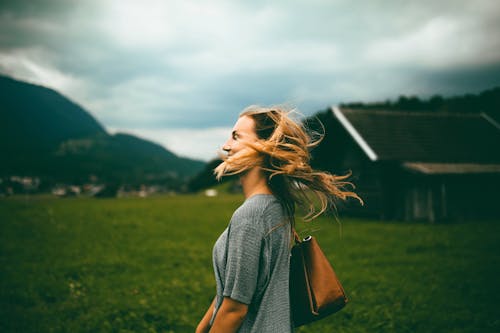 Free Woman Carrying Brown Leather Bag on Grass Field Stock Photo