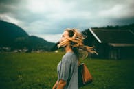 一名女子站在绿色的田野上，享受着乡村风景的自由和新鲜空气