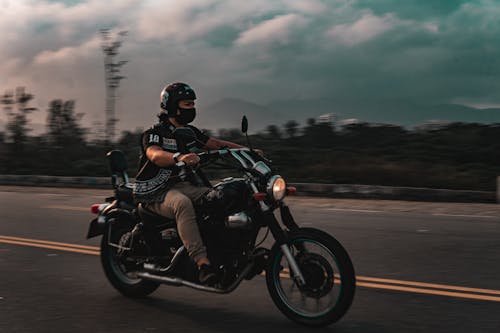 Man in Black Motorcycle Helmet Riding Motorcycle on Road