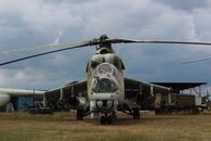 Gray Fighter Plane on Green Grass Field Under Blue Sky