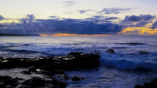 Sea Waves Crashing on the Rocky Shore during Sunset