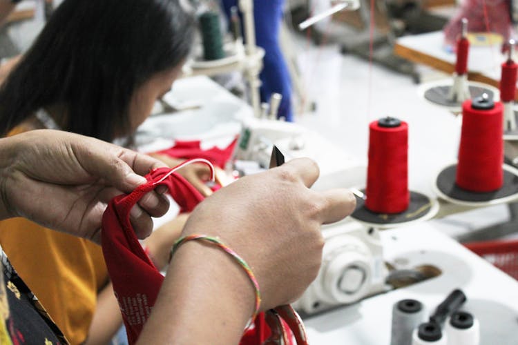 Woman Sewing Clothes In Workshop