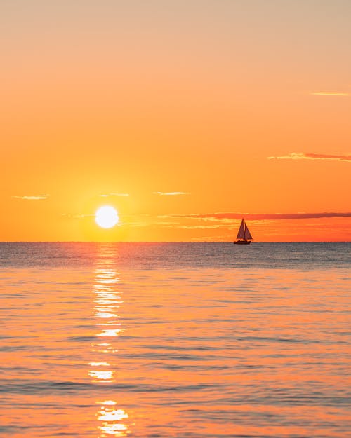 Sailboat on Sea Water during Sunset