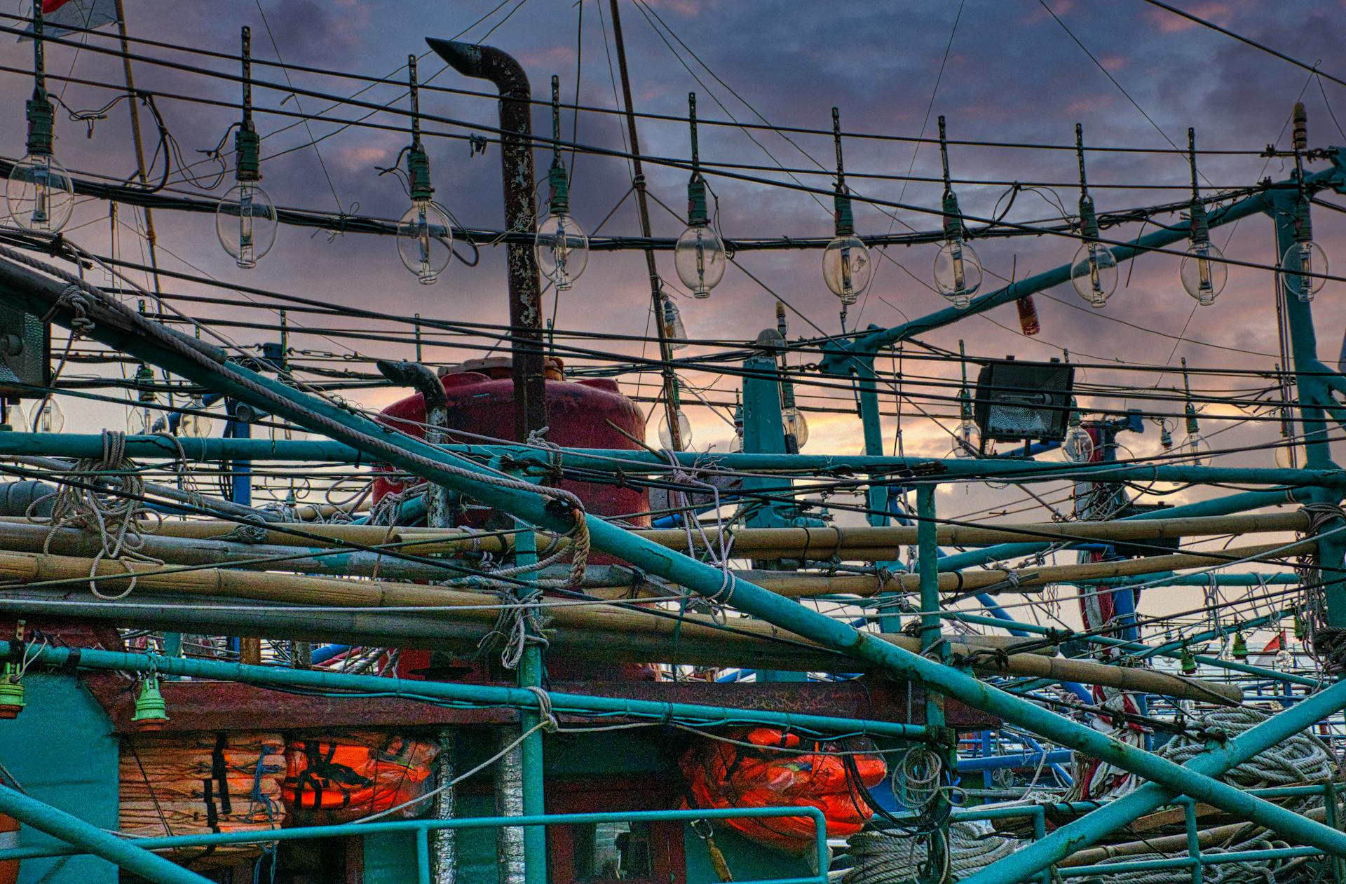 Detailed view of fishing boat rigging in Jakarta during sunset, showcasing maritime equipment and industry.