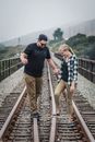 Man and Woman Walking on Train Rail