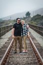 Man in Black Polo Shirt Standing Beside Woman in Black Long Sleeve Shirt on Train Rail