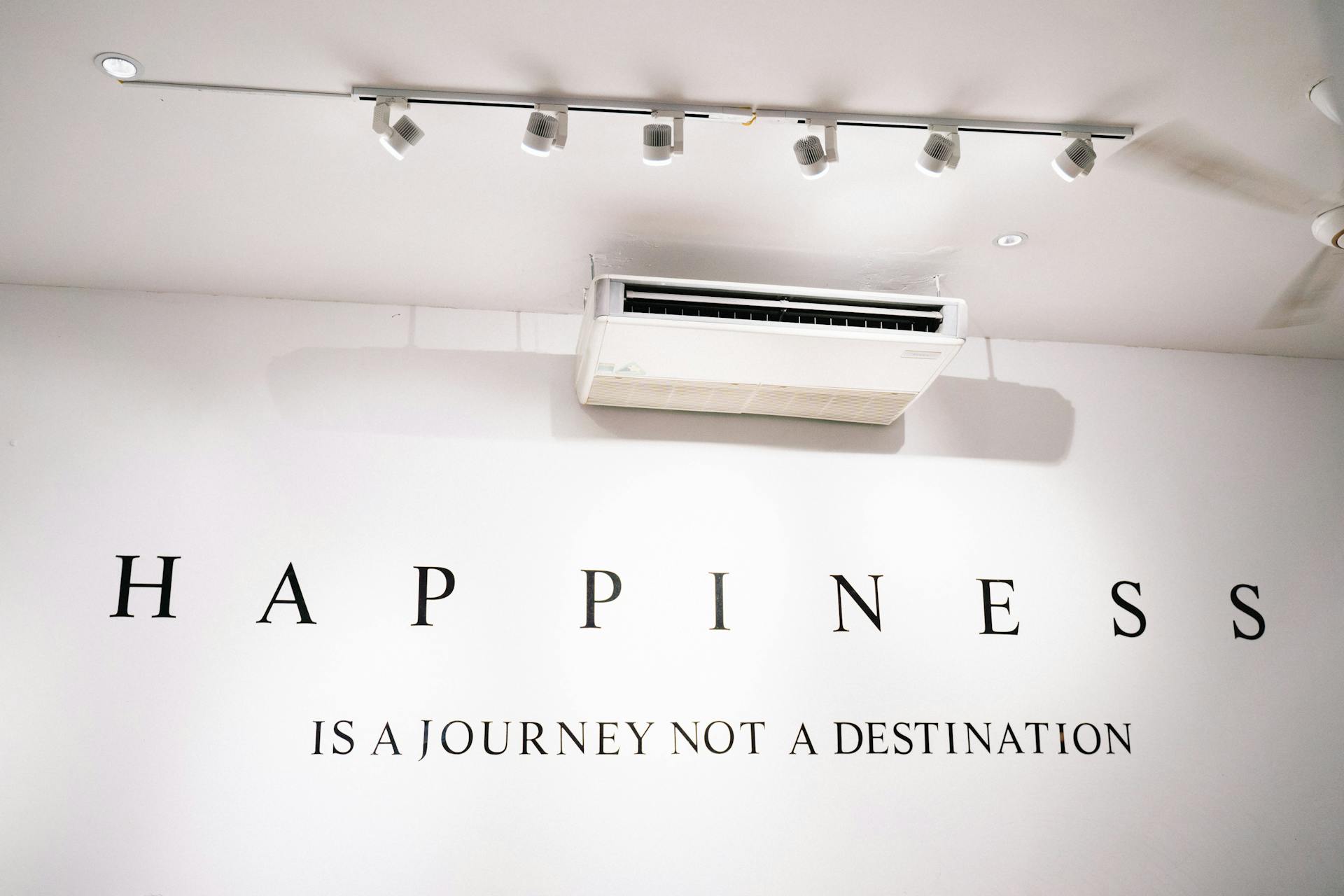 Minimalist wall with an inspirational quote about happiness.