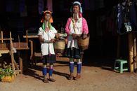 Two Kayah women in traditional attire at a market in Loikaw, Myanmar, showcasing cultural heritage.
