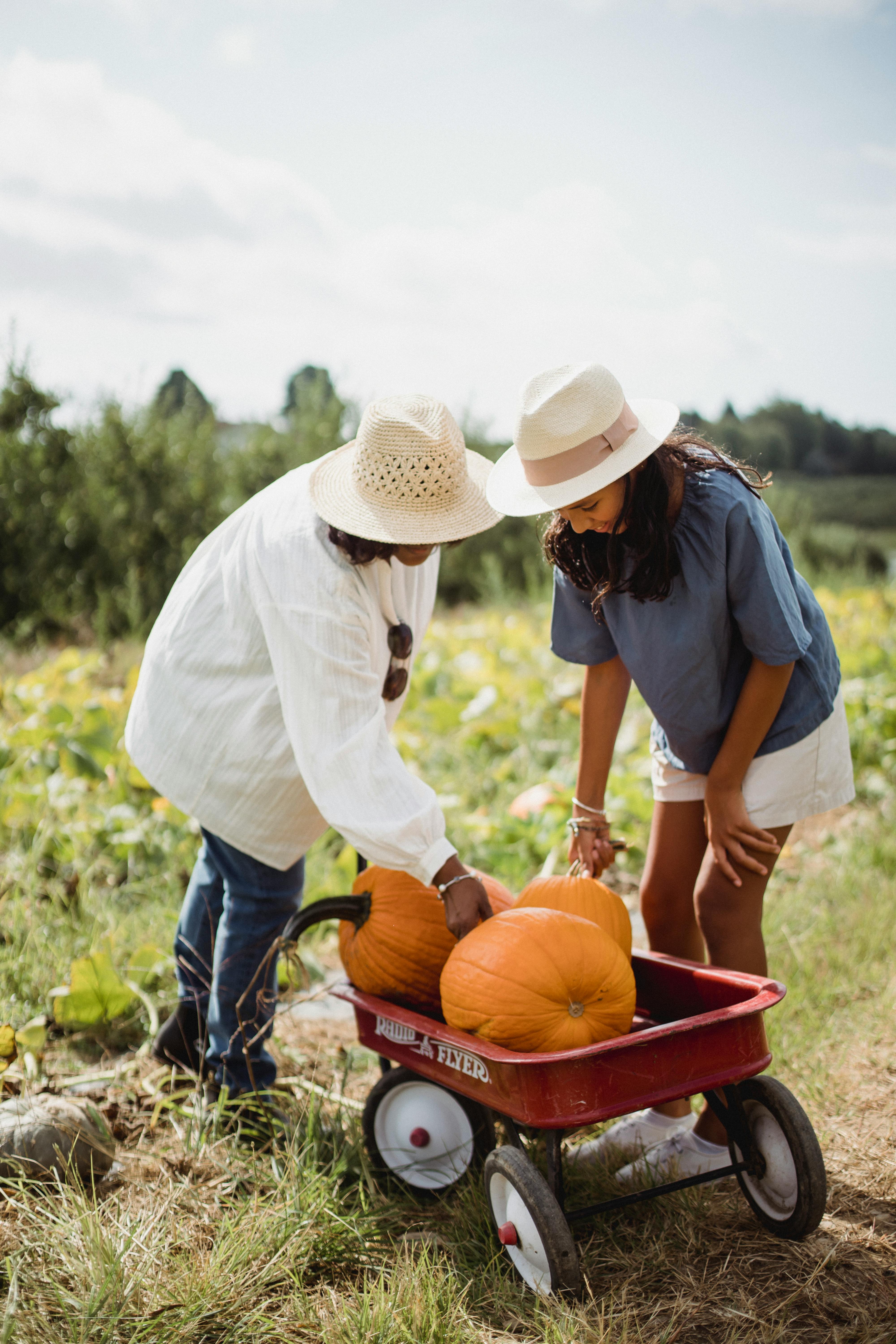 woman with daughter in field with pumpkins