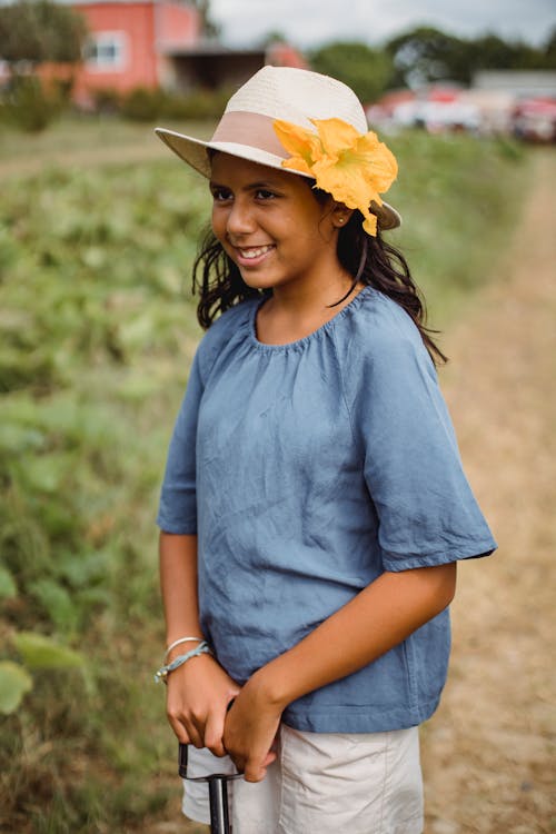 免費 快樂的西班牙裔少女與花在帽子裡 圖庫相片