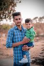 Young Man Carrying Little Boy 