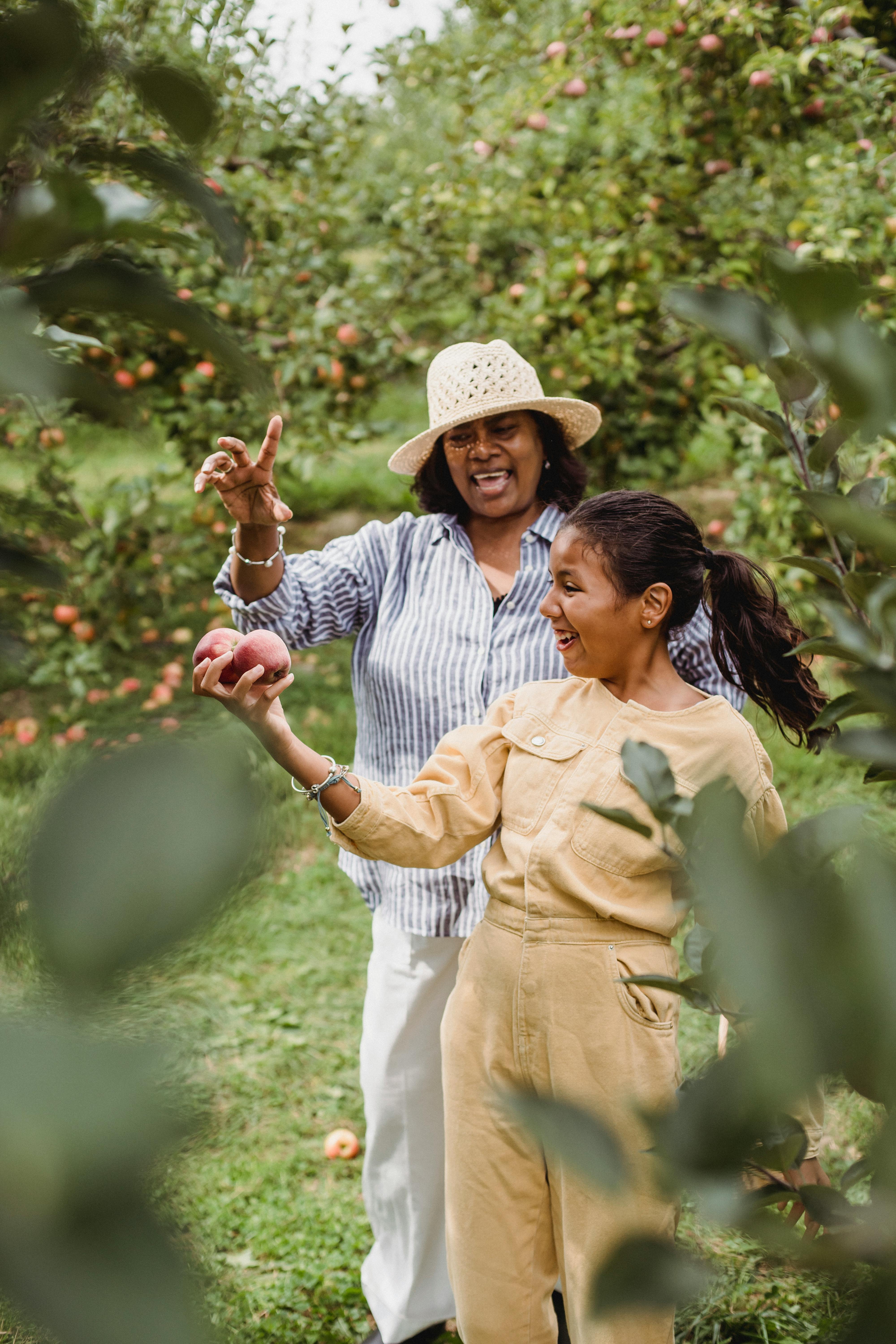 happy hispanic woman and young girl with apples