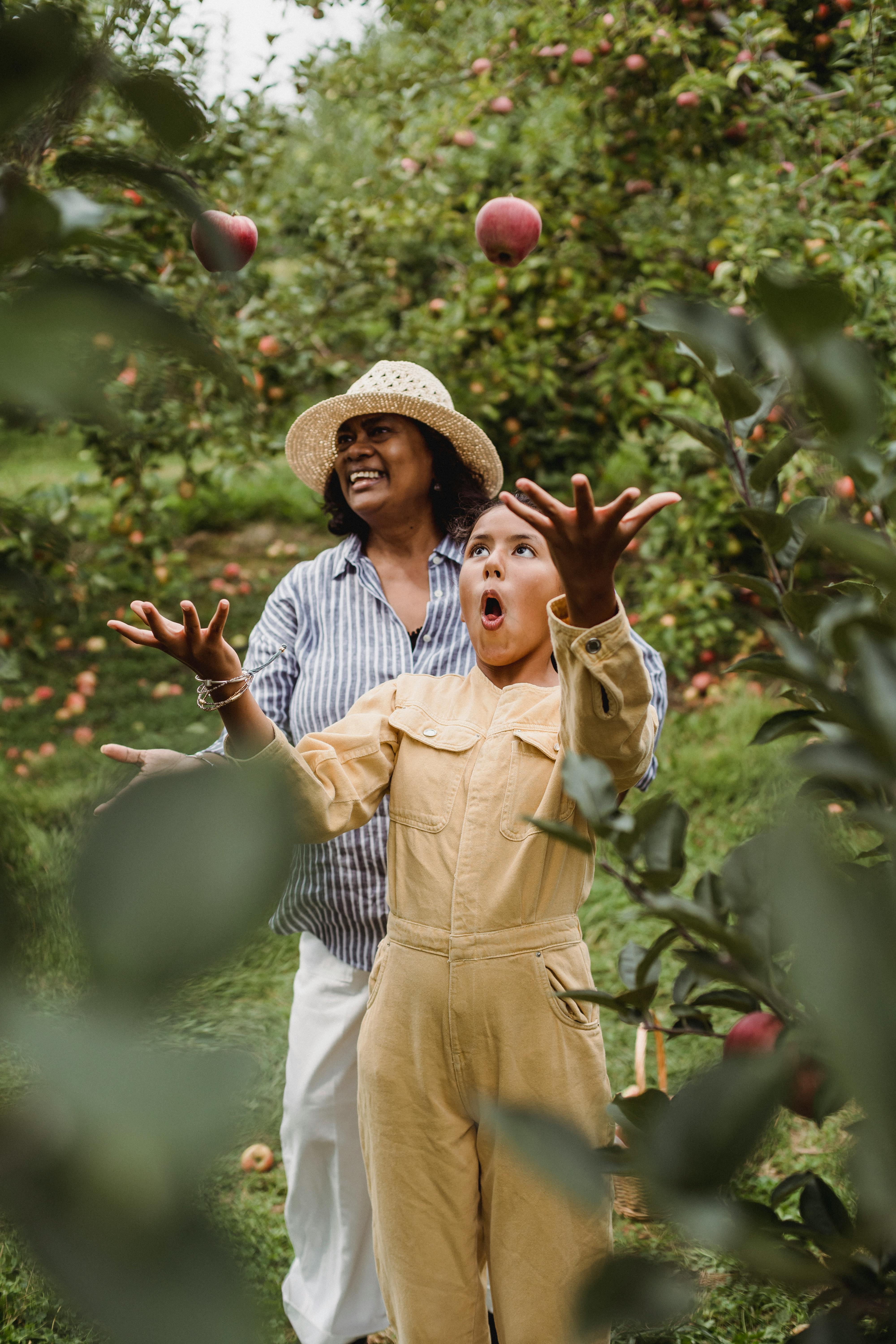 hispanic woman and young girl smiling in orchard