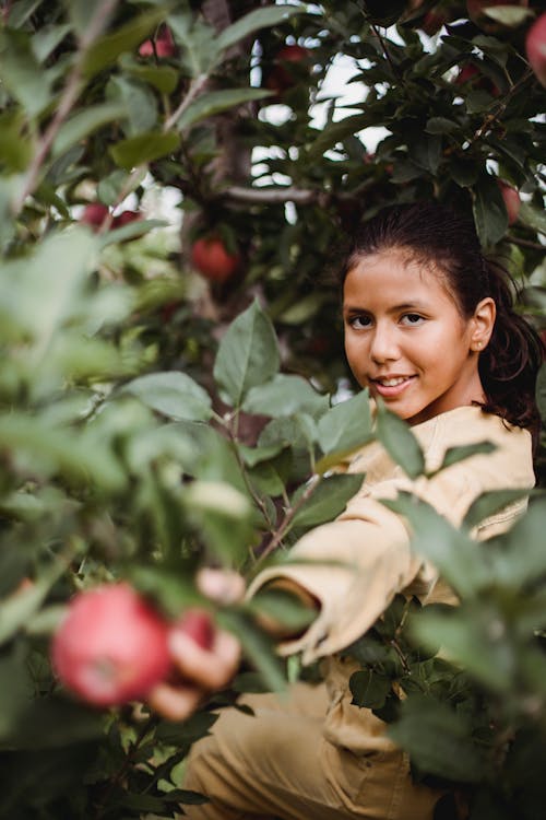 Hispanic teen girl in garden with apples