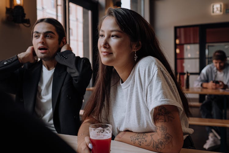 Photo Of A Woman In A Gray Shirt Listening To Her Friend