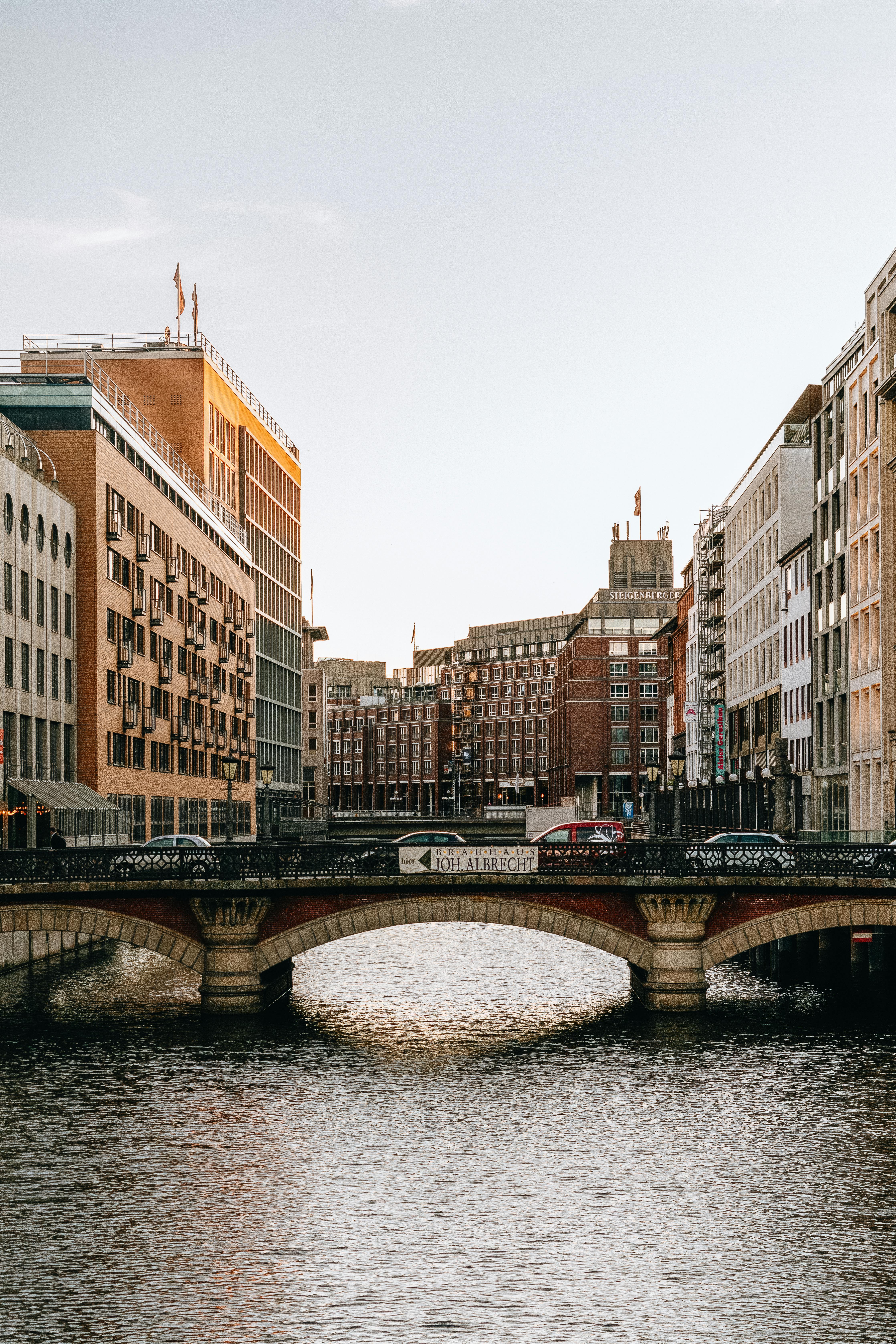 Exterior of arched bridge and buildings facades above flowing water of city river