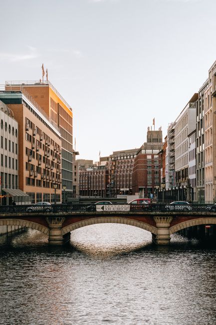 Exterior of arched bridge and buildings facades above flowing water of city river