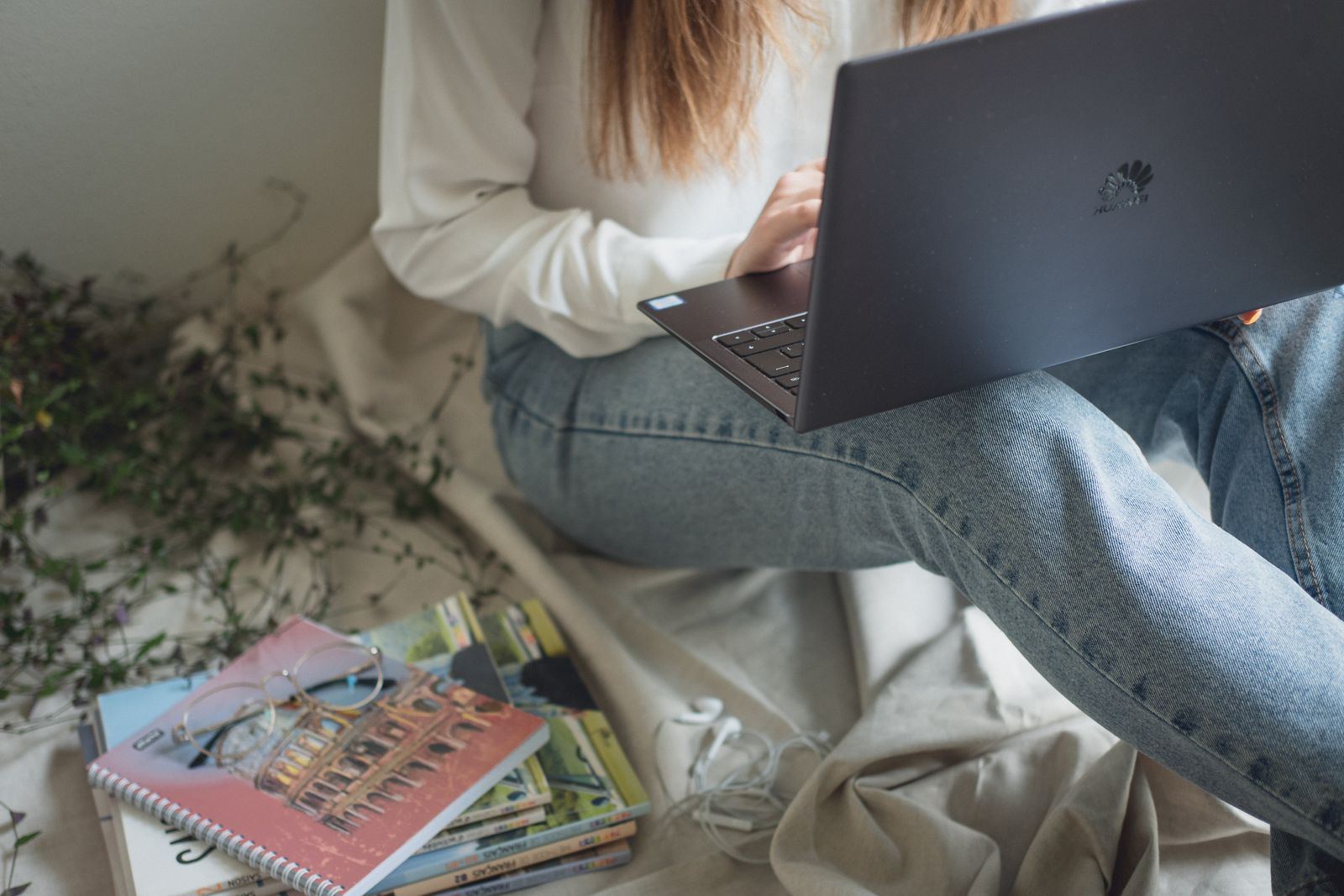 A woman studying calmly at home with a laptop and books.