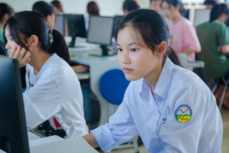 Young Girl In Blue Shirt Using Computer