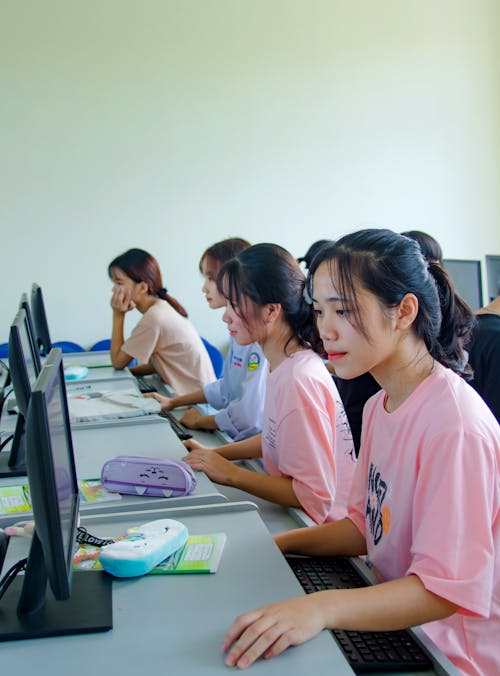 Girl in Pink T-Shirt Using Computer in the Class