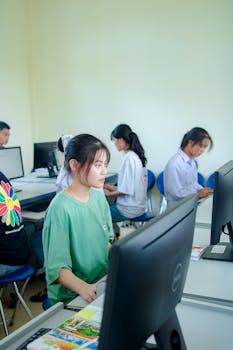 Group of students studying in a computer lab, focused on teamwork and education.