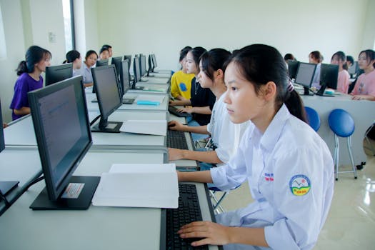 Students engaged in study at a computer lab, focused on technology and teamwork.