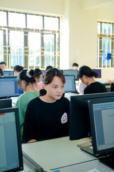 学生们在明亮的教室里专注地使用电脑