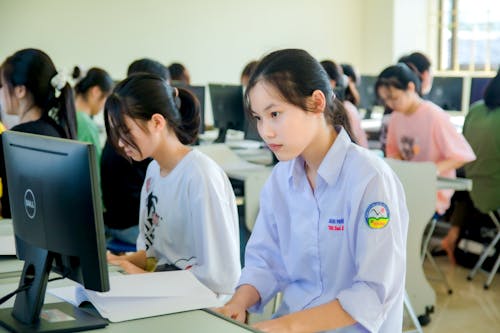 Free Woman in White School Uniform Sitting Beside Woman in White Shirt Stock Photo