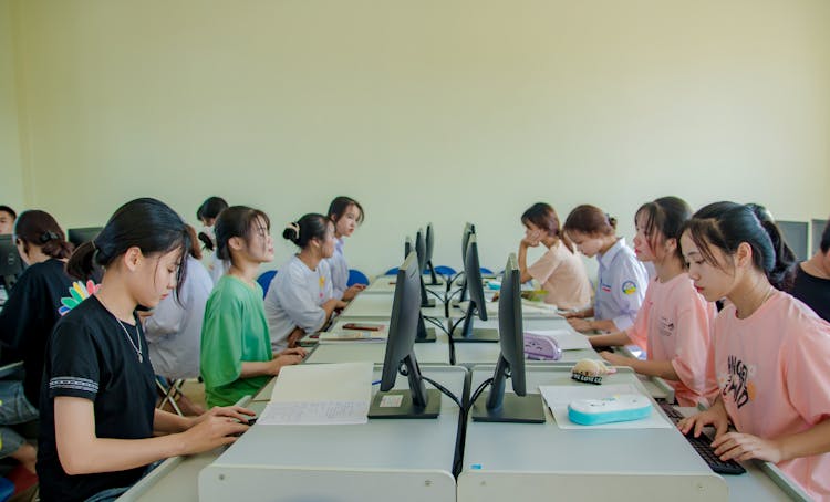 Group Of People Sitting On Chair While Using Computer