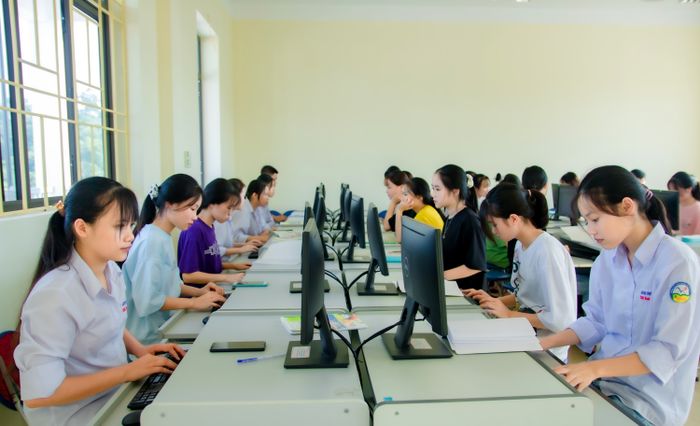 Grupo de estudiantes trabajando en computadoras en clase