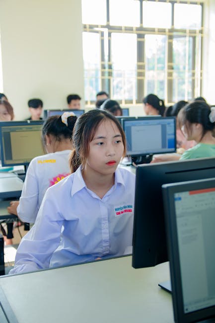 A modern workspace with professionals engaged in digital learning and collaborative work.. Thanks to Thành Đỗ for the photo