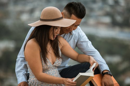 Uomo In Camicia Di Vestito Bianca E Donna In Libro Di Lettura Del Vestito Senza Maniche Bianco