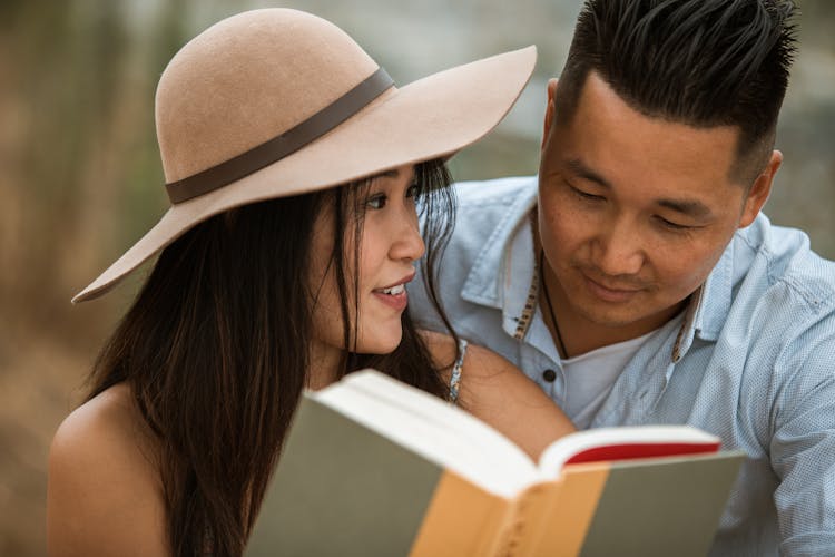 Close-up Photo Of A Happy Couple Reading A Book